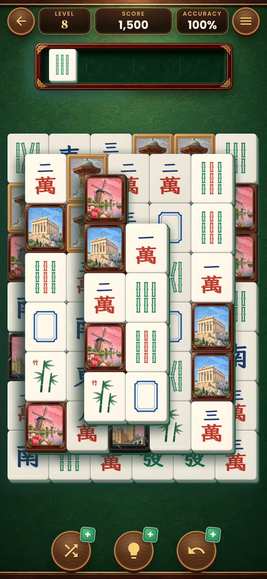 A Mahjong board mid level, picture tiles and classic tiles stacked in layers, one tile waiting in the box